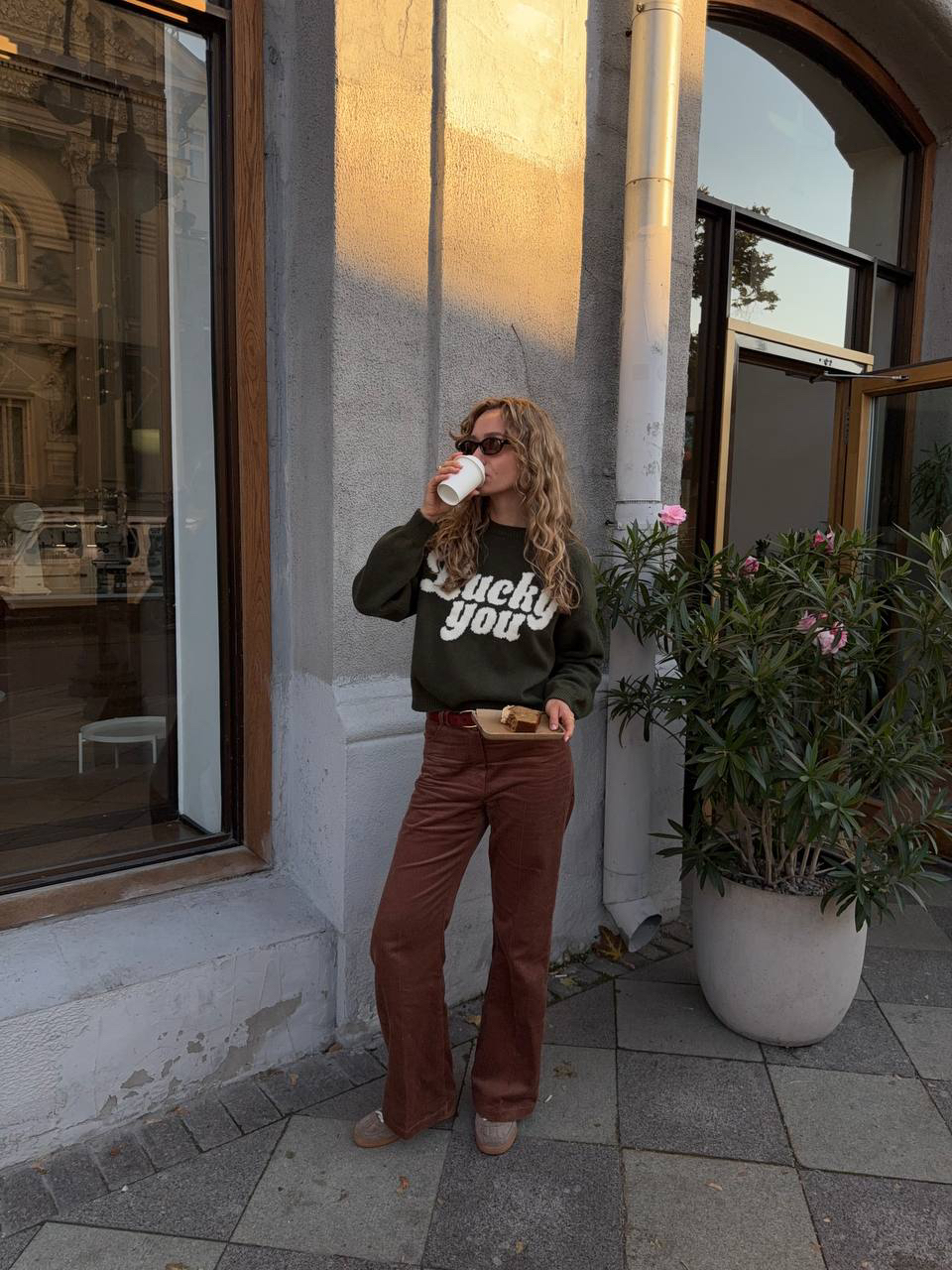 Один из наших любимых цветовых тандемов сезона — определено «кофе + потемневшая от дождя листва». Внушает спокойствие, убеждает в любви к осени и просто радует глаз.

Особенно хорошо нужную атмосферу передают джемпер с надписью Lucky You и брюки клеш из фактурного вельвета.

В подарок к образу (как и при заказе любого джемпера из коллекции «Нить удачи») мы обязательно вкладываем красную нить: ее можно повязать на запястье или ручку сумки. Верим, что так можно день за днем вплетать в свою реальность удачу. Проверим?